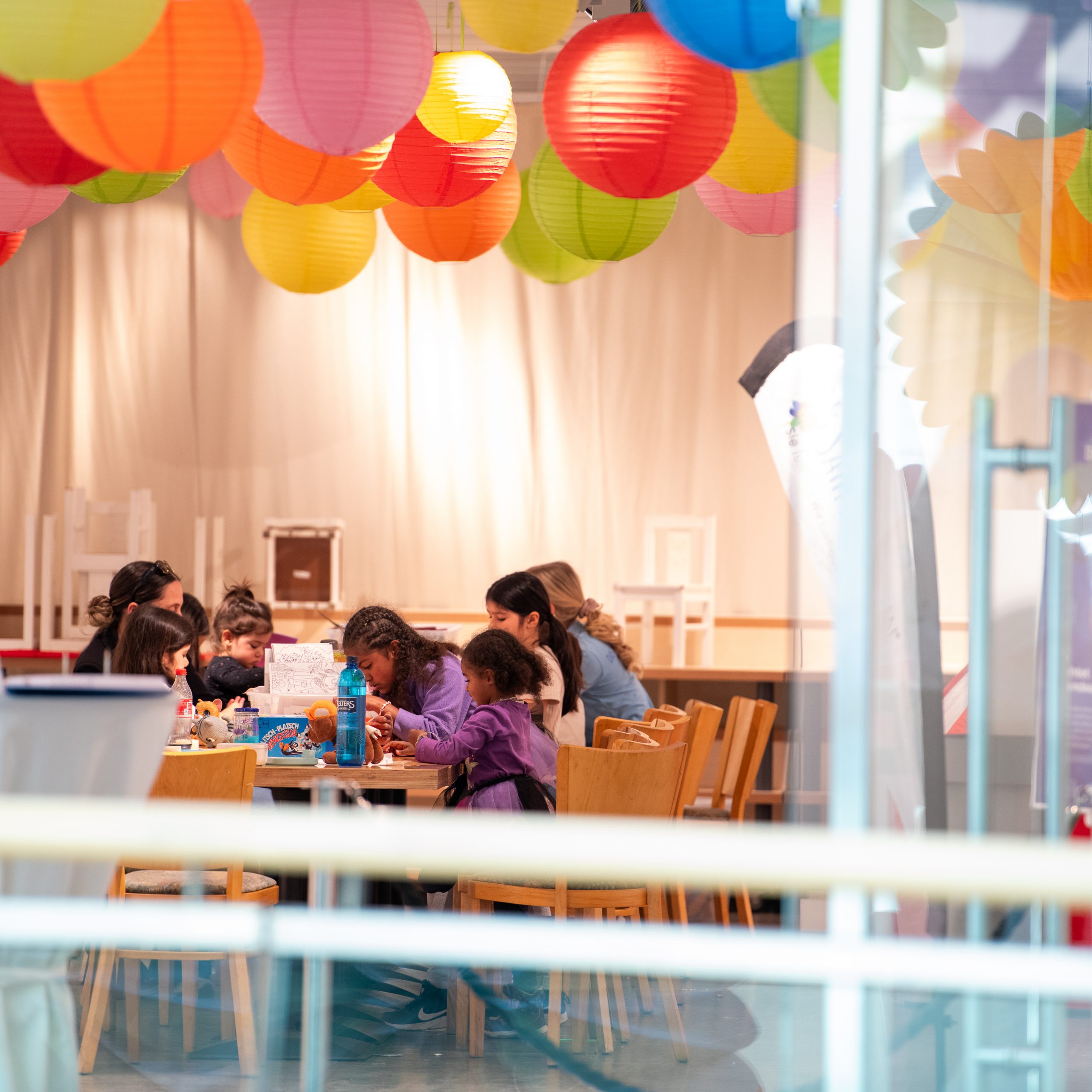 Kinder beim Basteln unter Papierlampions