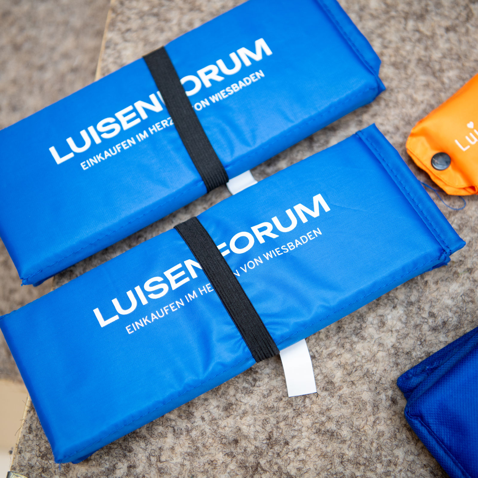Zwei zusammengefaltete blaue Kühltaschen mit dem weißen Schriftzug „LuisenForum – Einkaufen im Herzen von Wiesbaden“.